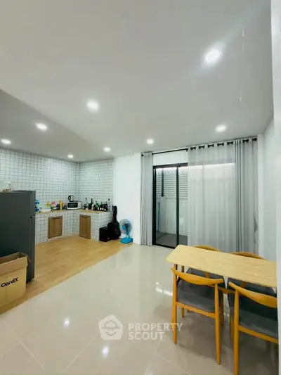 Modern kitchen with open layout and dining area, featuring sleek appliances and stylish decor.