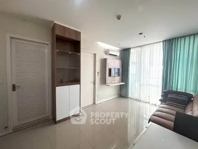 Modern living room with sleek furniture and large windows offering natural light.