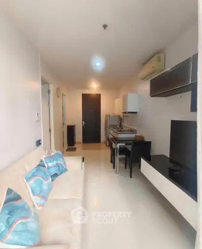 Modern living room with sleek furniture and open layout, featuring a cozy sofa and dining area.