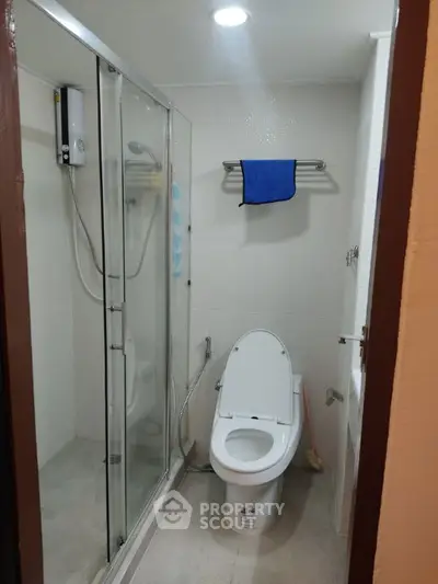 Modern bathroom with glass shower and sleek toilet design.
