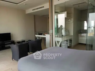 Modern bedroom with open layout and glass partition to bathroom