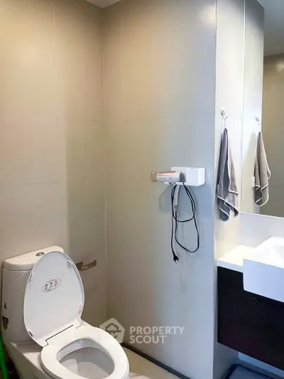 Modern bathroom with sleek fixtures and wall-mounted hairdryer