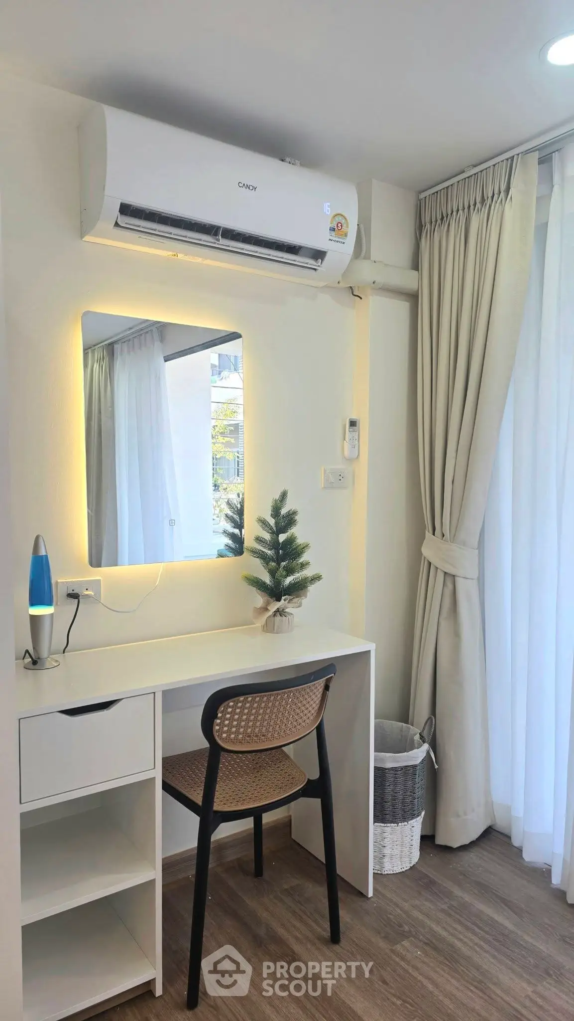 Modern study area with desk, chair, and air conditioning in bright apartment