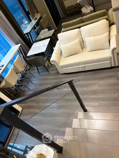 Modern living room with stylish furniture and sleek staircase in a contemporary apartment.