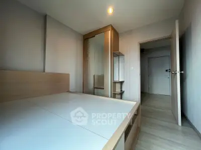 Modern minimalist bedroom with sleek wooden furniture and ample natural light.