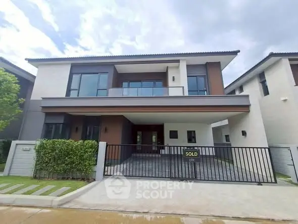 Modern two-story house with sleek design and spacious balcony in a serene neighborhood.