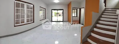 Spacious modern living room with large windows and staircase
