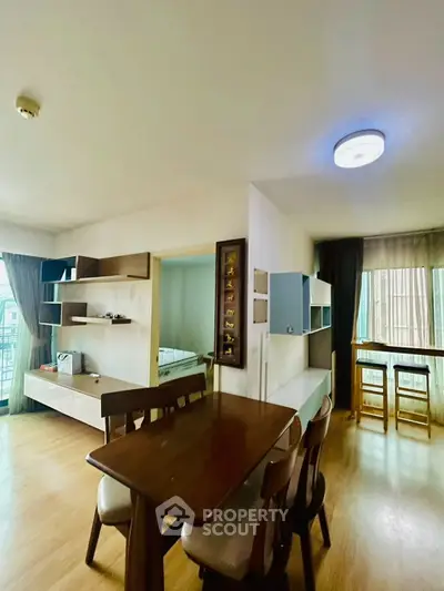 Spacious living area with modern dining set and natural light, perfect for family gatherings.