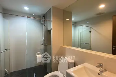 Modern bathroom with glass shower and sleek fixtures in a contemporary apartment.