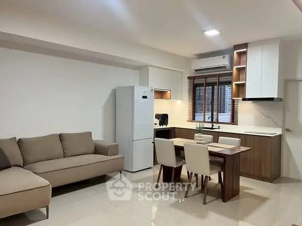 Modern open-plan kitchen and living room with sleek furniture and natural light.