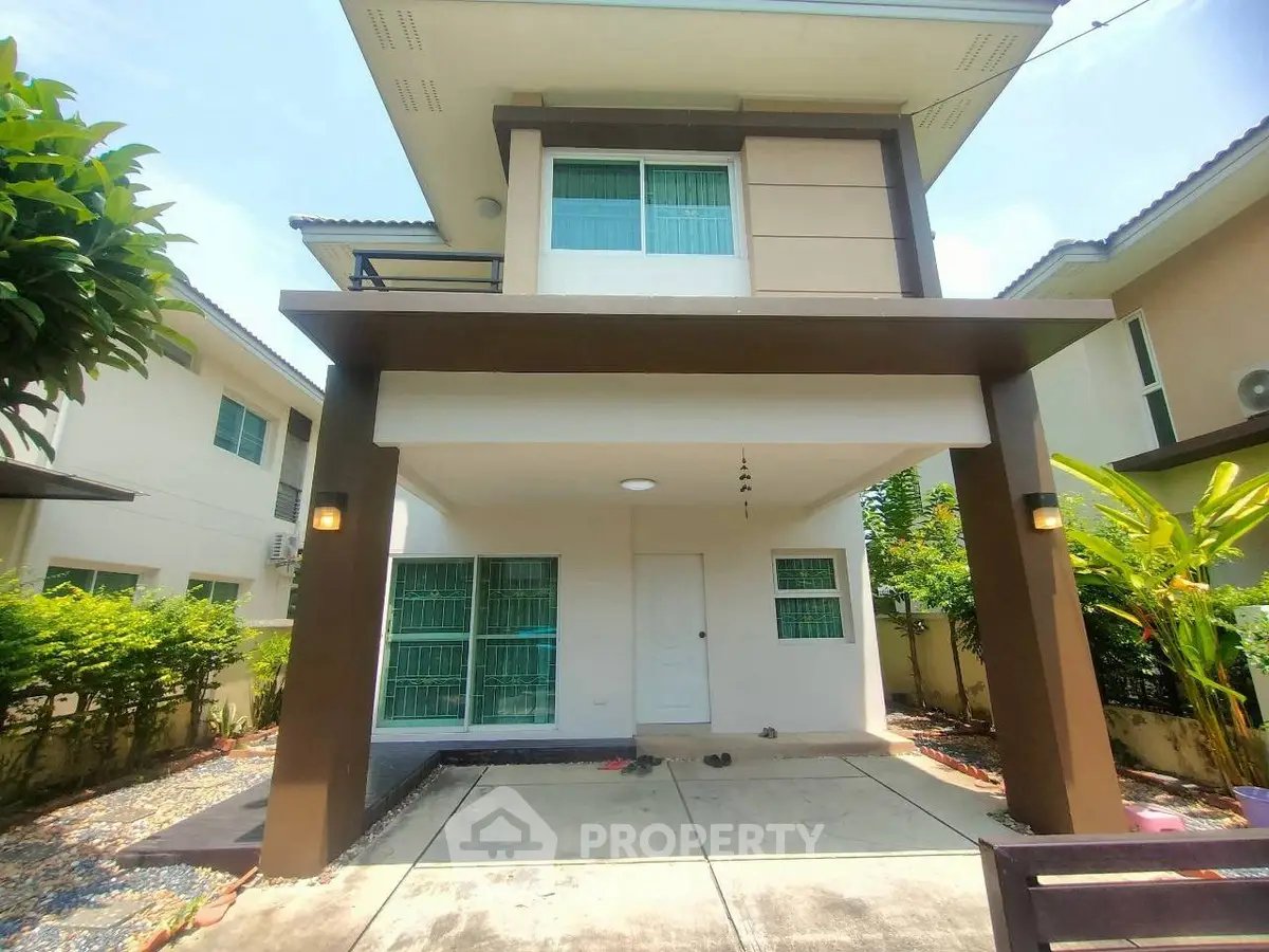 Modern two-story house with driveway and lush greenery in a suburban setting.