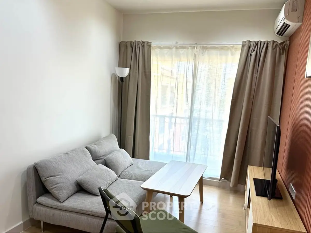 Cozy living room with modern furniture and natural light from large window.