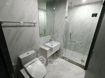 Modern bathroom with glass shower and sleek fixtures in a stylish real estate property.