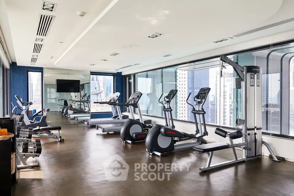 Luxurious high-rise gym with modern fitness equipment and city views.