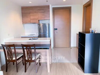 Modern kitchen with wooden cabinets and dining area in cozy apartment