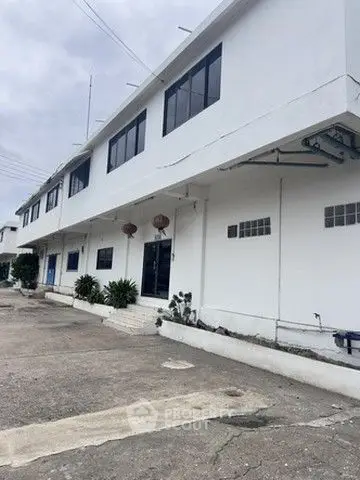 Spacious industrial building with ample parking and modern facade, ideal for business operations.