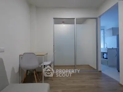 Modern apartment interior with study area and kitchen, featuring sleek design and ample natural light.