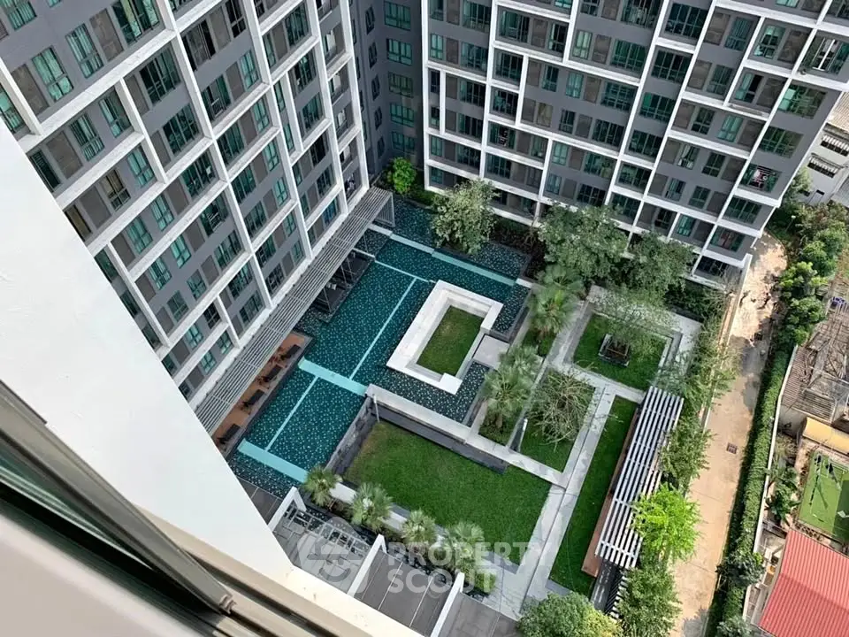 Stunning aerial view of modern residential complex with pool and lush garden.