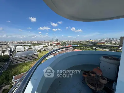 Stunning cityscape view from a high-rise balcony with clear blue skies.