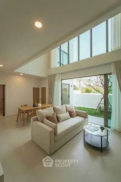 Spacious modern living room with high ceilings and garden view