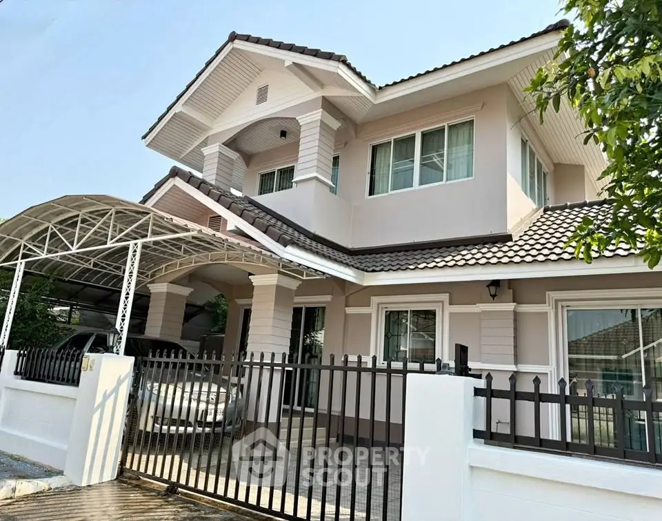 Charming two-story house with carport and gated entrance, perfect for family living.