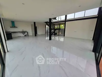 Spacious modern living room with sleek design and spiral staircase, featuring large windows for natural light.