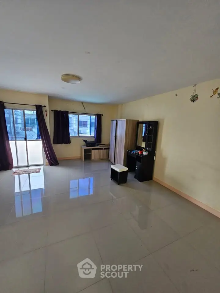 Spacious living room with large windows and modern furniture, perfect for natural light lovers.