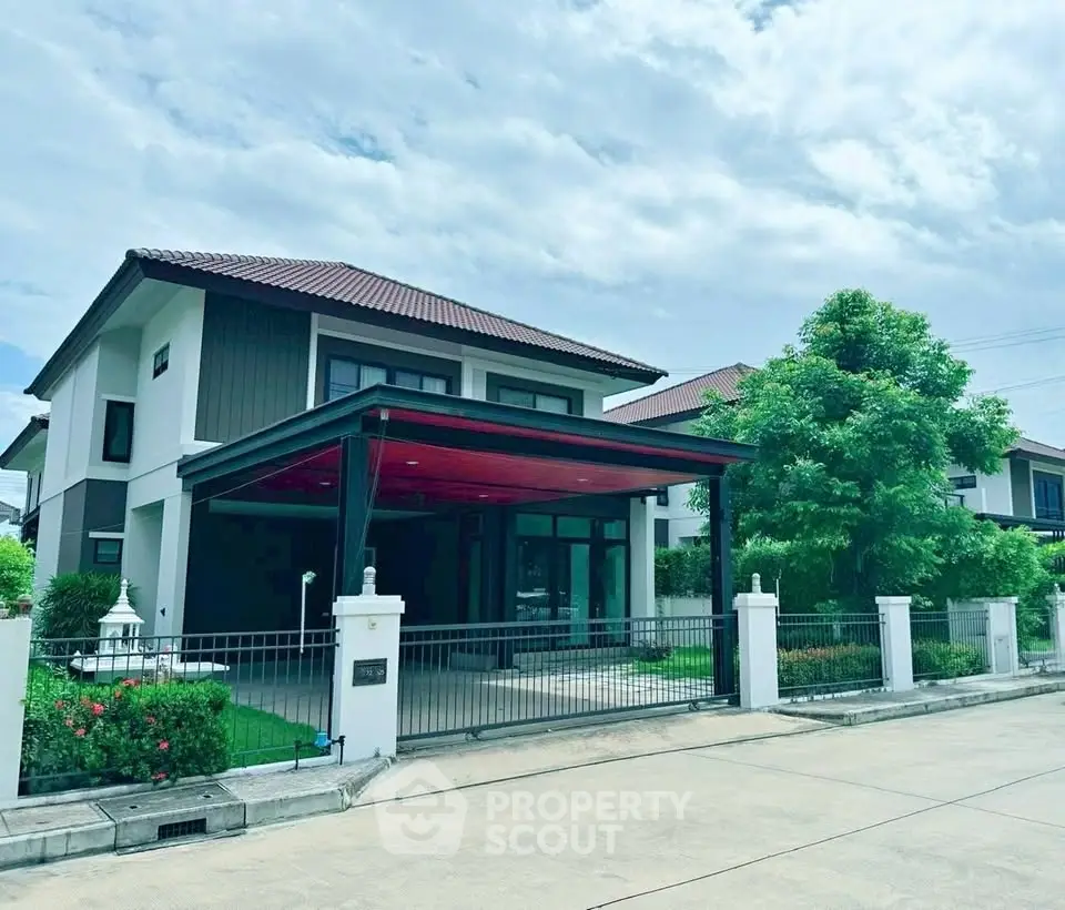 Modern two-story house with spacious driveway and lush greenery in a serene neighborhood.