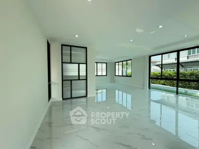 Spacious modern living room with large windows and glossy tile flooring