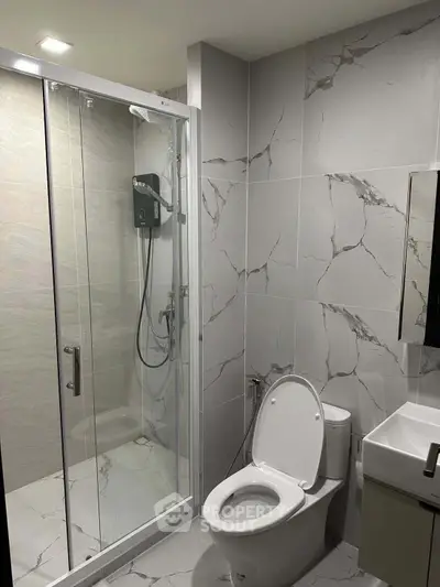 Modern bathroom with marble tiles and glass shower enclosure