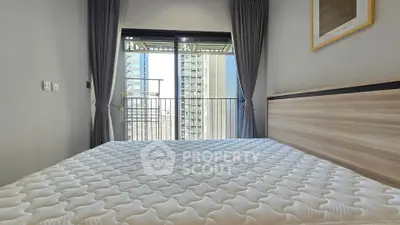 Modern bedroom with large window and city view, featuring a comfortable bed and stylish decor.