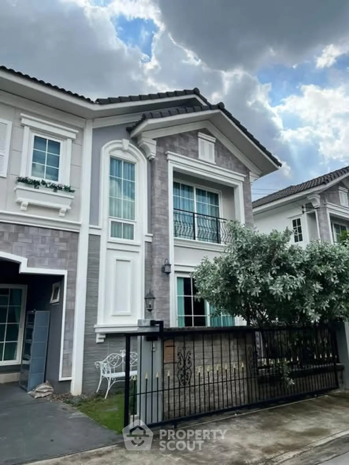 Elegant two-story house with modern facade and lush greenery, perfect for family living.