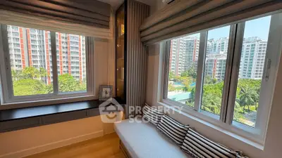 Modern apartment with large windows offering stunning city views and cozy seating area.