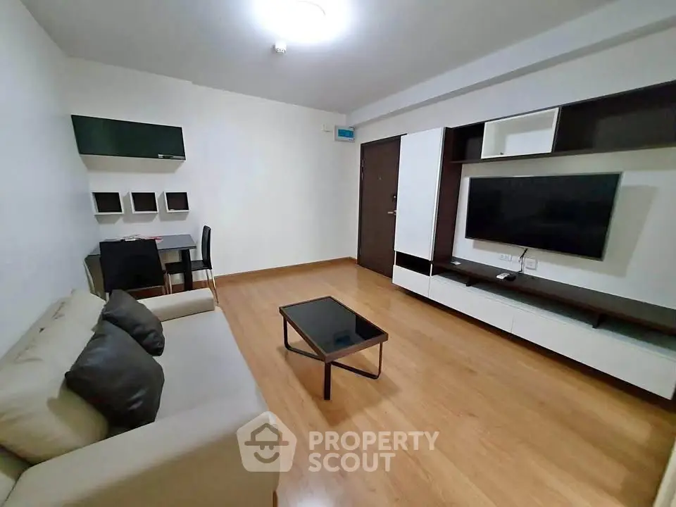 Modern living room with sleek furniture and wooden flooring, perfect for cozy gatherings.