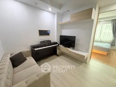 Modern living room with piano and TV, adjacent to a cozy bedroom, showcasing stylish interior design.