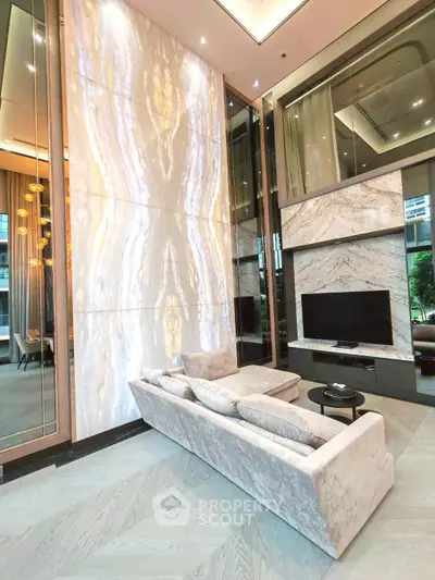 Luxurious living room with high ceilings, elegant marble wall, and plush sofa in modern apartment.