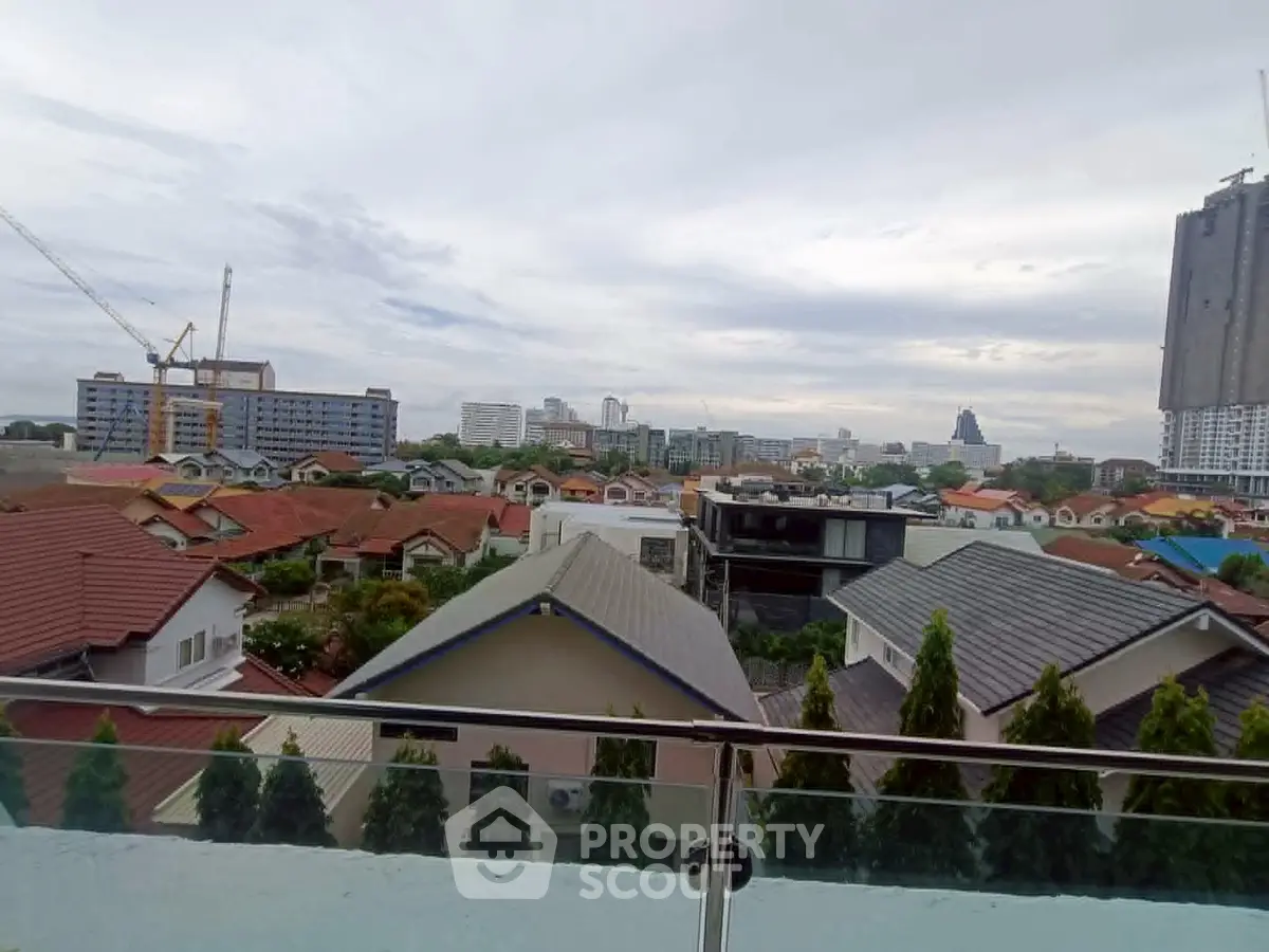 Stunning cityscape view from a modern balcony overlooking urban rooftops and skyline.