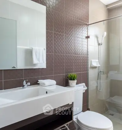 Modern bathroom with sleek fixtures and glass shower enclosure.