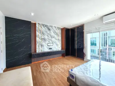 Spacious modern bedroom with elegant marble accent wall and large windows