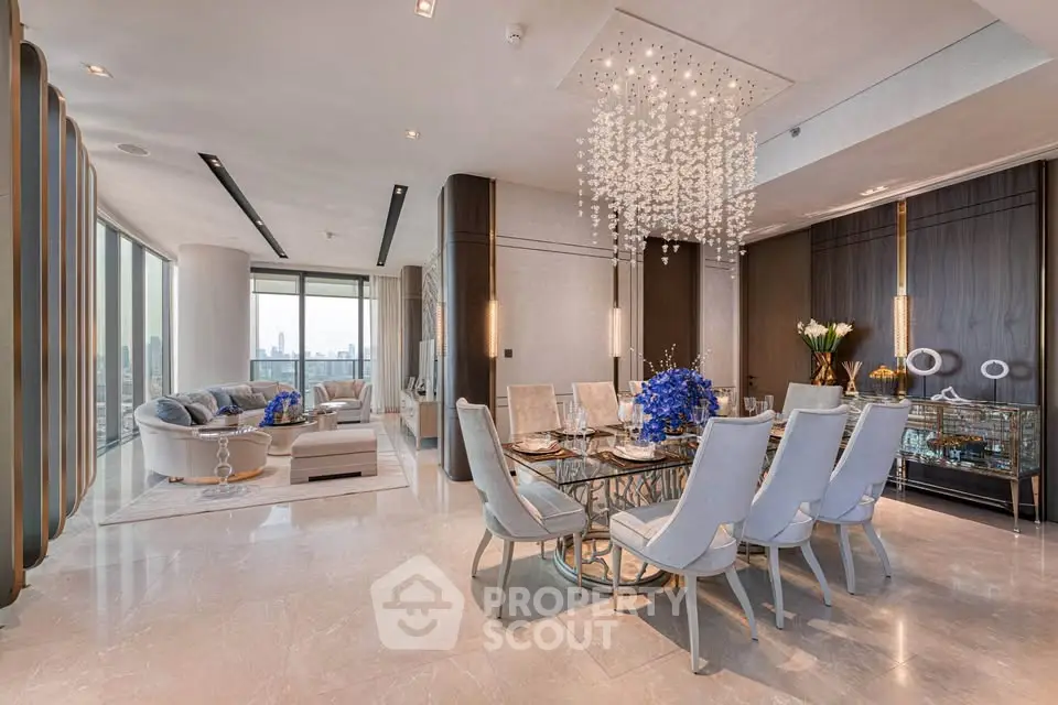 Luxurious open-plan living and dining area with elegant chandelier and panoramic city views.
