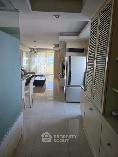 Spacious open-layout living room with modern kitchen and large windows