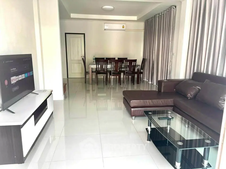 Spacious modern living room with sleek furniture and dining area, perfect for entertaining.
