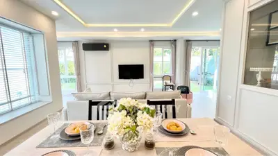 Spacious modern living room with elegant dining area and large windows for natural light.