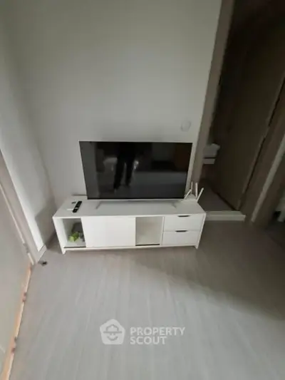 Modern living room with sleek TV stand and flat-screen TV, perfect for entertainment setup.