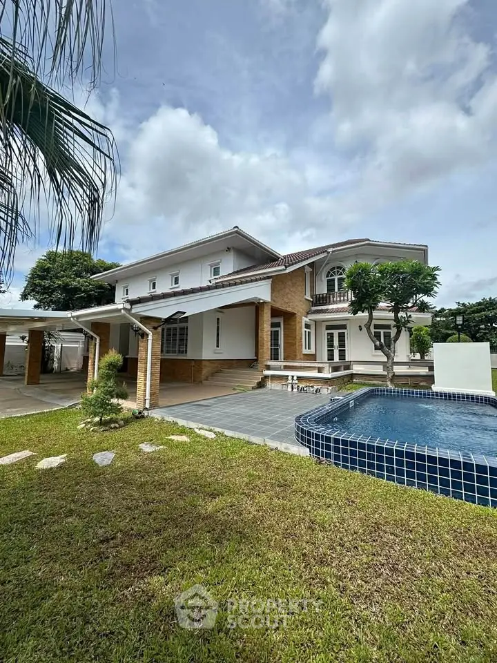 Stunning two-story house with pool and lush garden, perfect for luxurious living.
