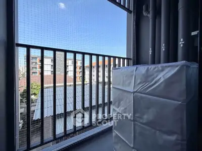Urban balcony view with protective cover and cityscape backdrop.