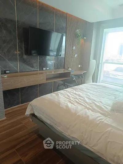 Modern bedroom with stylish decor and large window offering city view