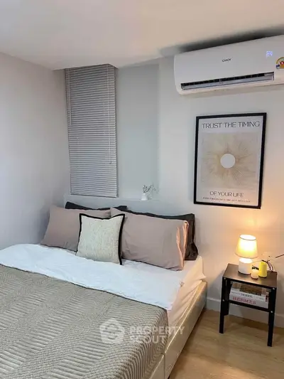 Cozy bedroom with modern decor and air conditioning, perfect for relaxation.