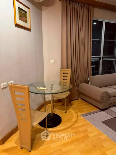 Cozy living room with modern furniture and glass table, perfect for relaxation and entertaining.