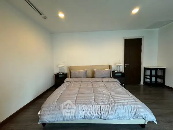Spacious bedroom with modern decor and cozy ambiance, perfect for relaxation.